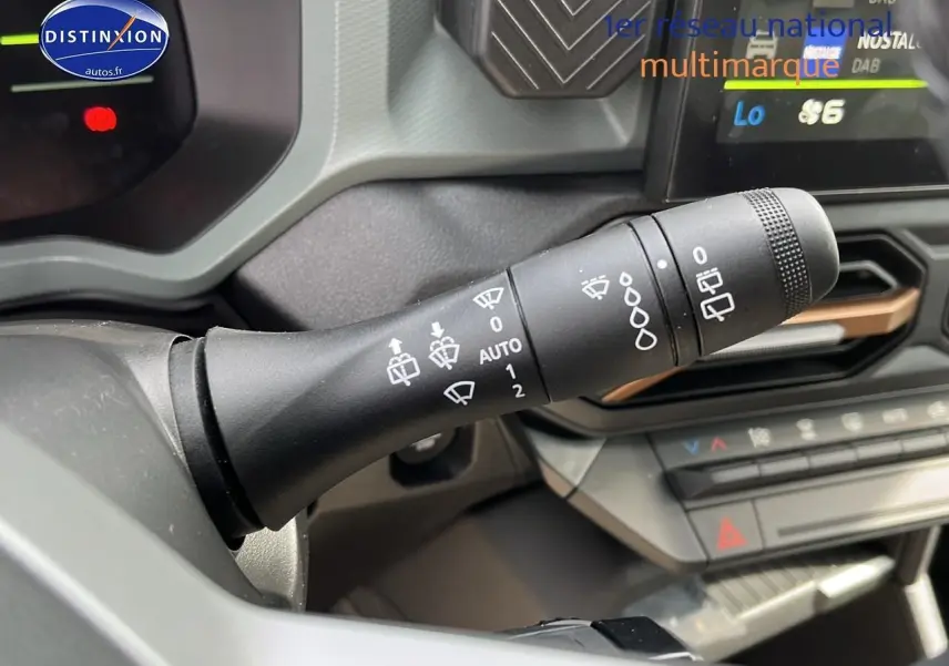 Gros plan sur la commande d'essuie-glace du Dacia Duster 2025 couleur Sandstone, intérieur moderne avec écran tactile.