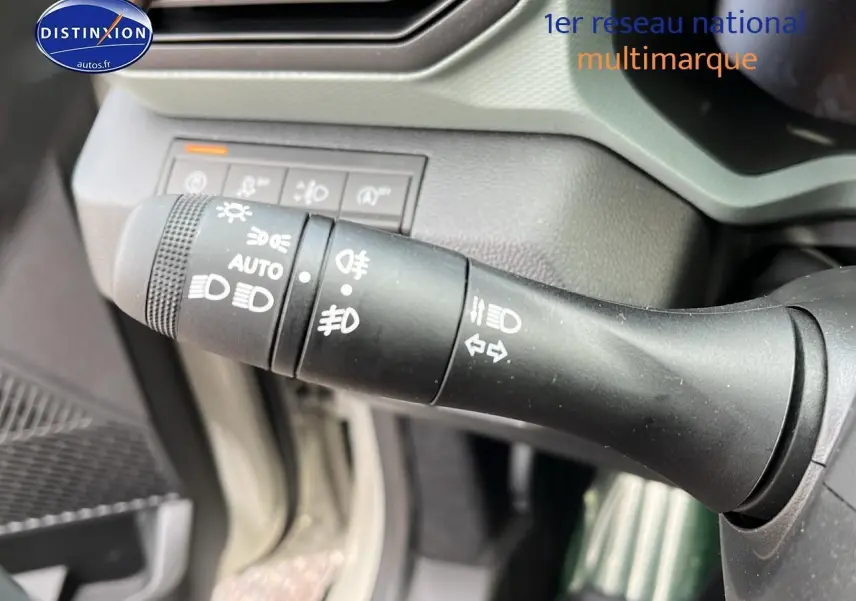 Gros plan sur la commande des phares et clignotants dans l'habitacle du Dacia Duster 2025 couleur Sandstone.