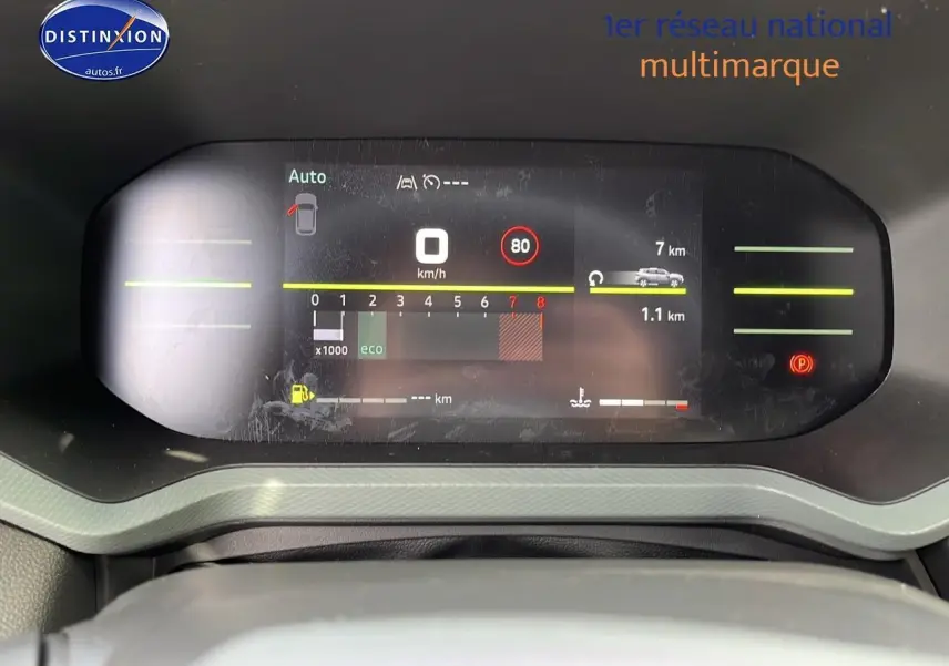 Tableau de bord numérique du Dacia Duster 2025 affichant vitesse, compte-tours et alertes, vue frontale rapprochée.