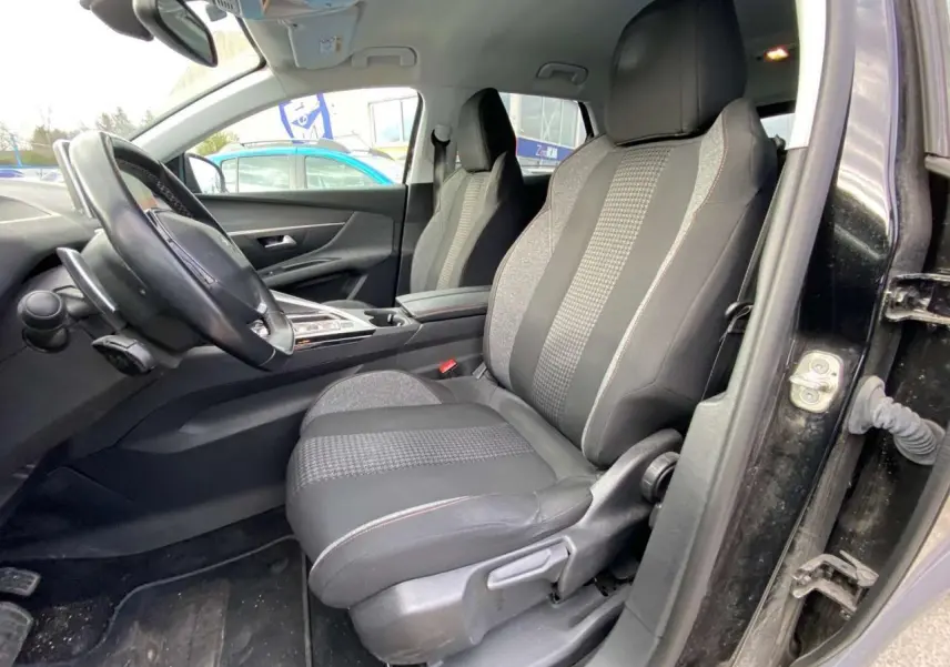 Intérieur du Peugeot 3008 noir 2019 vu côté conducteur, sièges tissu noir avec motifs et surpiqûres rouges visibles.
