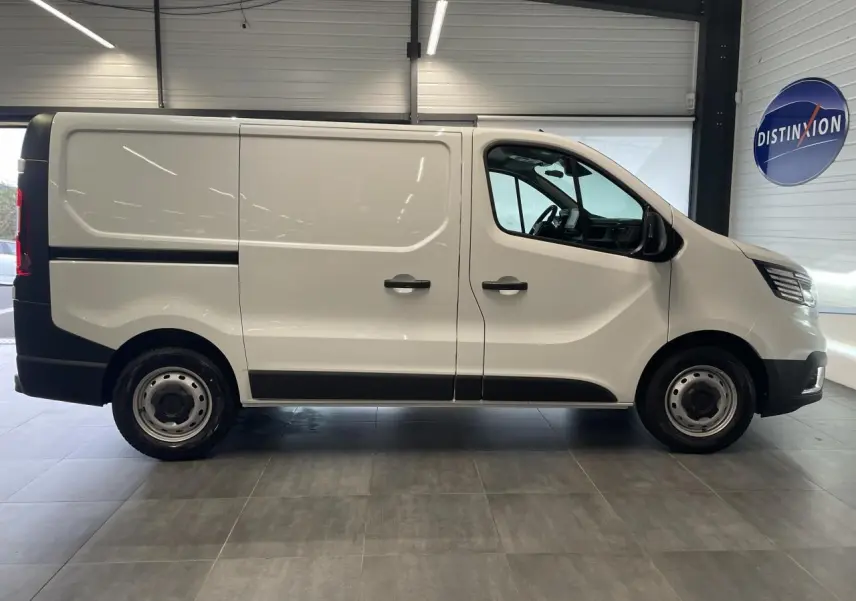 Profil droit du Renault Trafic Fourgon blanc Glacier L1H1, avec jantes tôles 16 pouces et poignées noires.