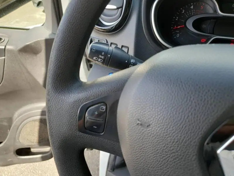 Gros plan sur le volant noir avec commandes audio et tableau de bord du Renault Trafic Fourgon blanc glacier 2019.