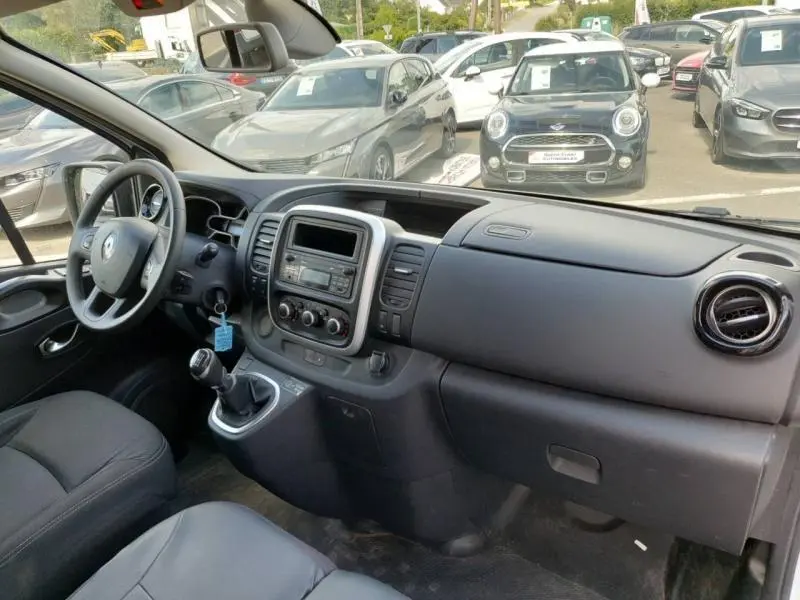 Vue intérieure côté conducteur du Renault Trafic Fourgon blanc glacier 2019, tableau de bord et volant visibles.