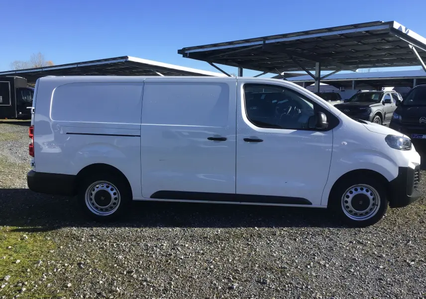 Profil latéral droit d’un FIAT Scudo Fourgon blanc 2024, version XL avec garde au sol rehaussée et jantes acier.