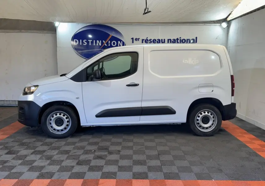 Vue de profil côté gauche d’un utilitaire Citroën Berlingo blanc avec jantes acier et protections noires sur les portes.
