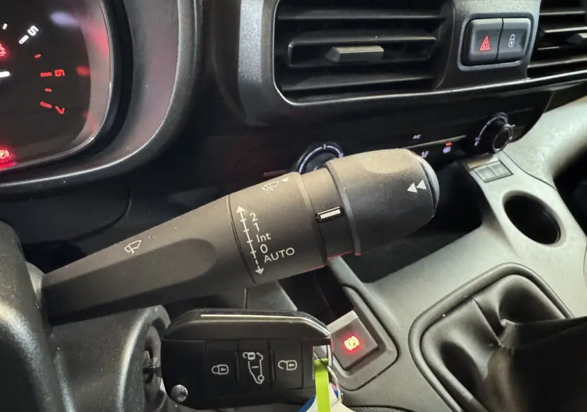 Gros plan intérieur sur la commande d’essuie-glace et la clé dans le contact d’un Citroën Berlingo blanc de 2020.
