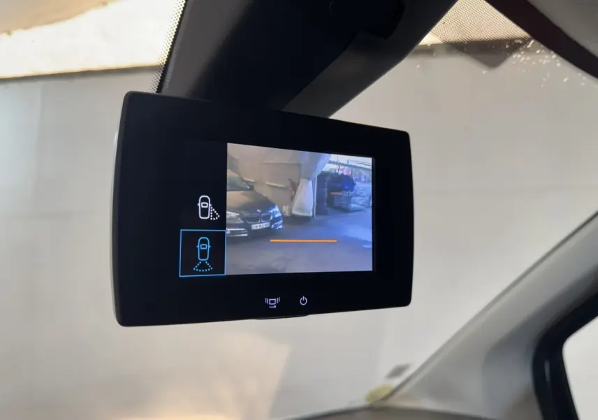 Écran de caméra de rétroviseur intérieur montrant une vue extérieure partielle du véhicule blanc Citroën Berlingo 2020.
