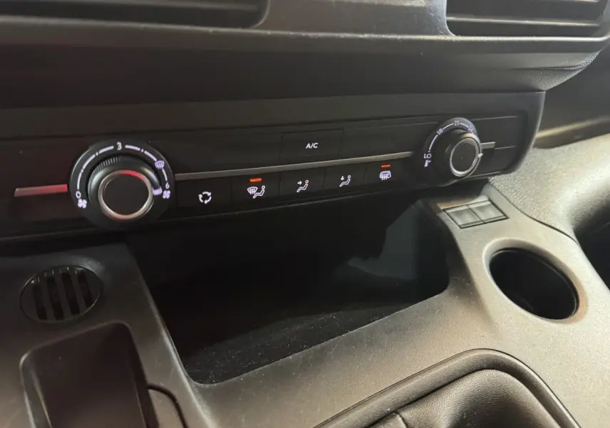 Gros plan sur la console centrale noire du Citroën Berlingo 2020, montrant les commandes de climatisation et ventilation.