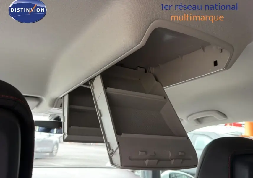 Vue intérieure du coffre à lunettes déplié au plafond d'un Volkswagen Touran blanc de 2018, avec sièges noirs visibles.