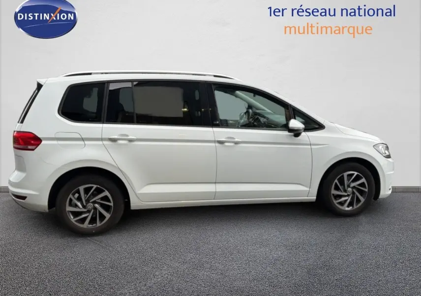 Profil droit d'un Volkswagen Touran blanc 2018 avec jantes alliage bicolores et vitres teintées.