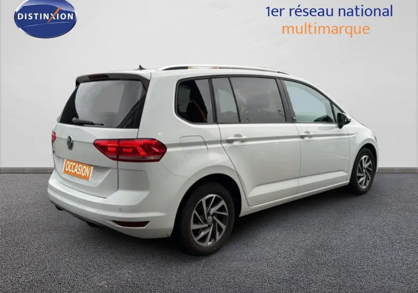 Vue 3/4 arrière droite d'un Volkswagen Touran blanc 2018 avec jantes alliage et feux arrière LED.