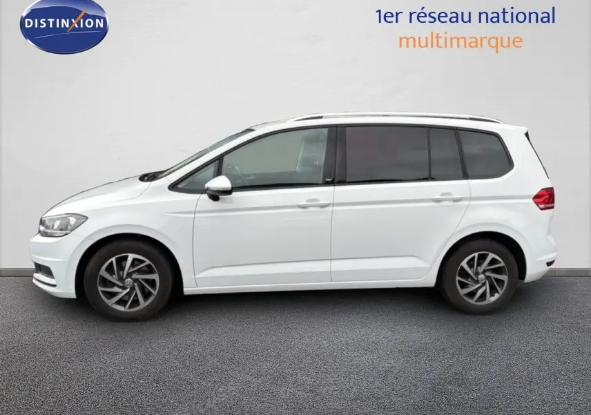 Profil droit d’un Volkswagen Touran blanc 2018 avec jantes alliage bicolores et vitres arrière teintées.