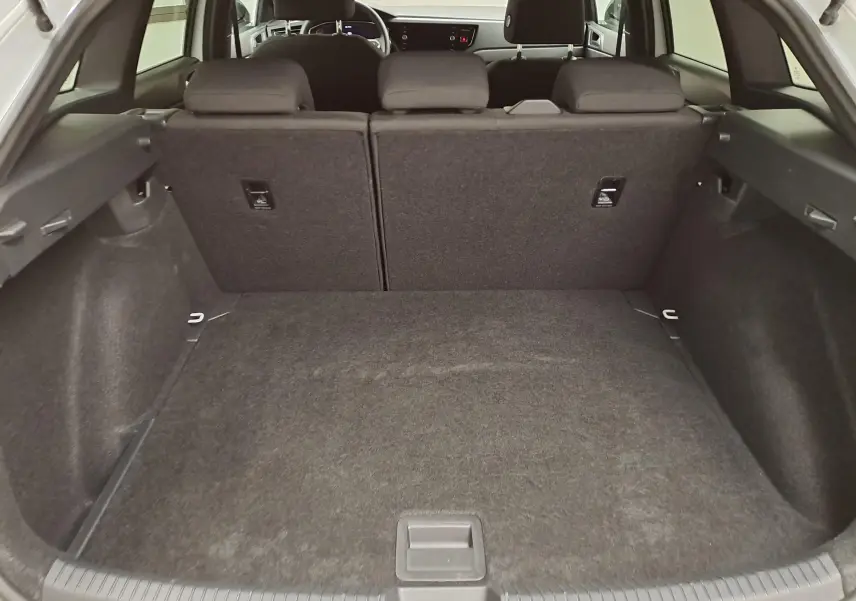 Vue intérieure du coffre spacieux du Volkswagen Taigo 2025, avec sièges arrière rabattables et finition noire.