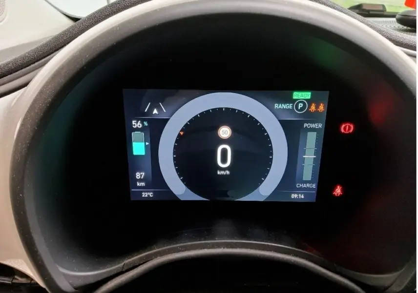 Vue rapprochée du tableau de bord numérique de la Fiat 500 électrique 2024, affichant vitesse et autonomie.