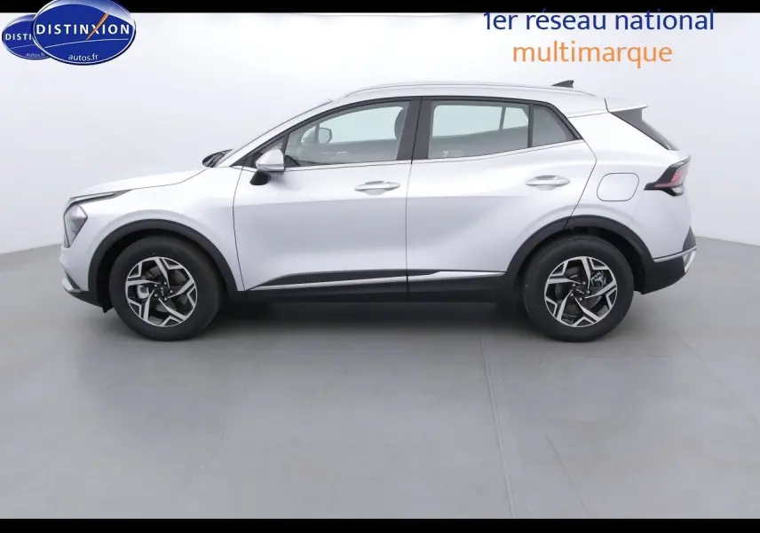 Vue de profil côté gauche du KIA SPORTAGE 2022 gris acier métal avec jantes bicolores et lignes modernes.