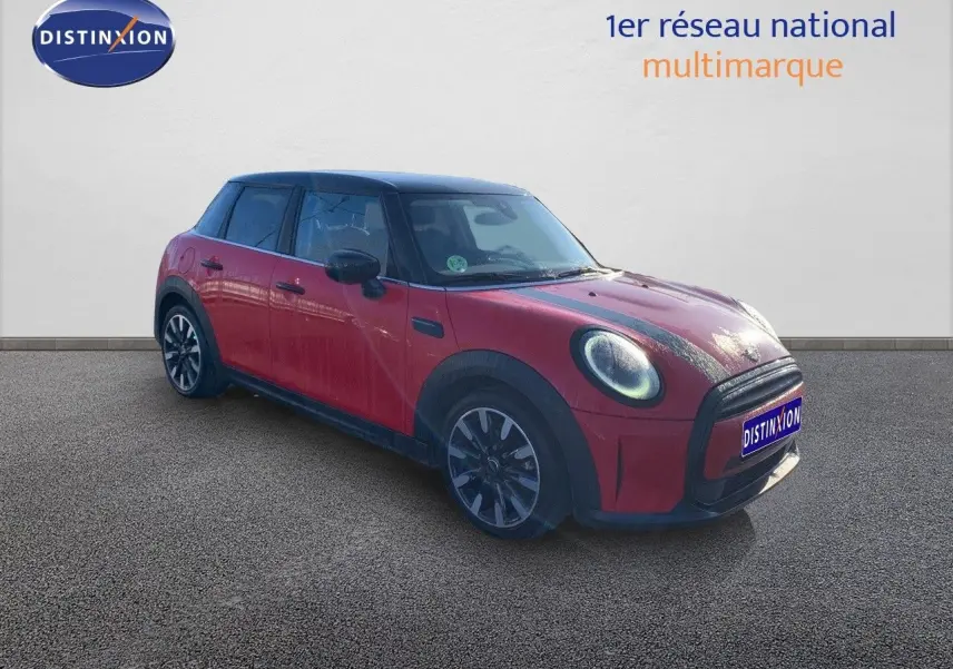 Vue 3/4 avant gauche d'une MINI 5 portes rouge chili avec toit noir et jantes alliage bicolores.