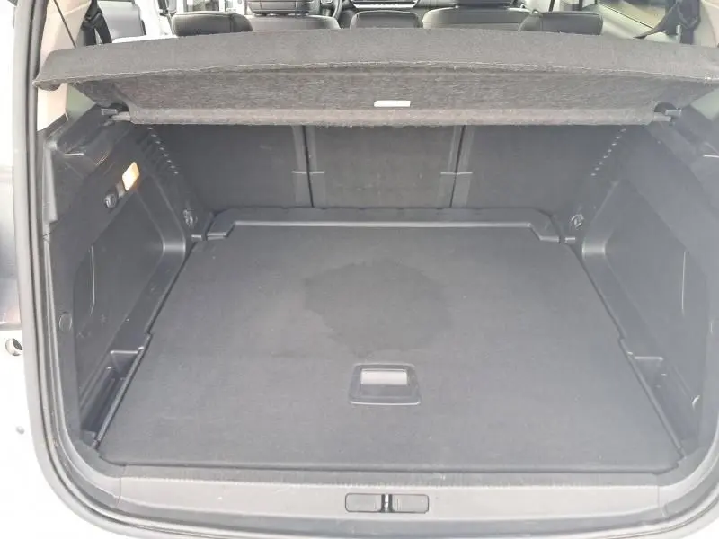 Coffre ouvert vu de l'arrière d'une Citroën C5 Aircross blanc 2019, avec cache-bagages et intérieur noir.