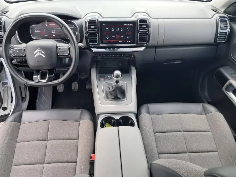 Intérieur du Citroën C5 Aircross blanc 2019, vue frontale du tableau de bord et console centrale avec boîte manuelle.