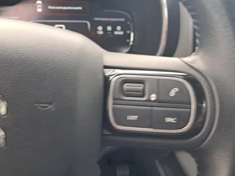 Gros plan sur les commandes au volant droit du Citroën C5 Aircross blanc HDi 130 Shine de 2019.