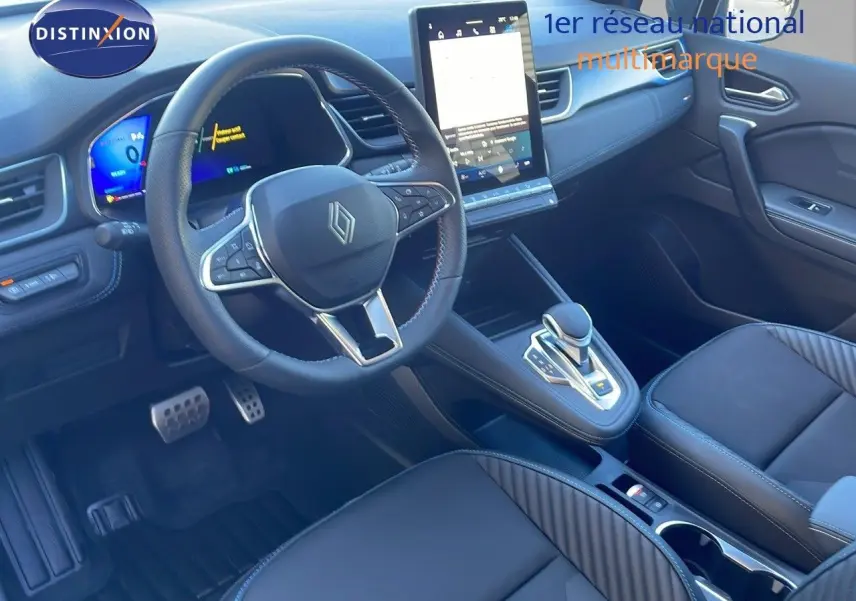 Intérieur du Renault Symbioz 2025 en bleu Iron Metal, vue côté conducteur sur le tableau de bord et la console centrale.