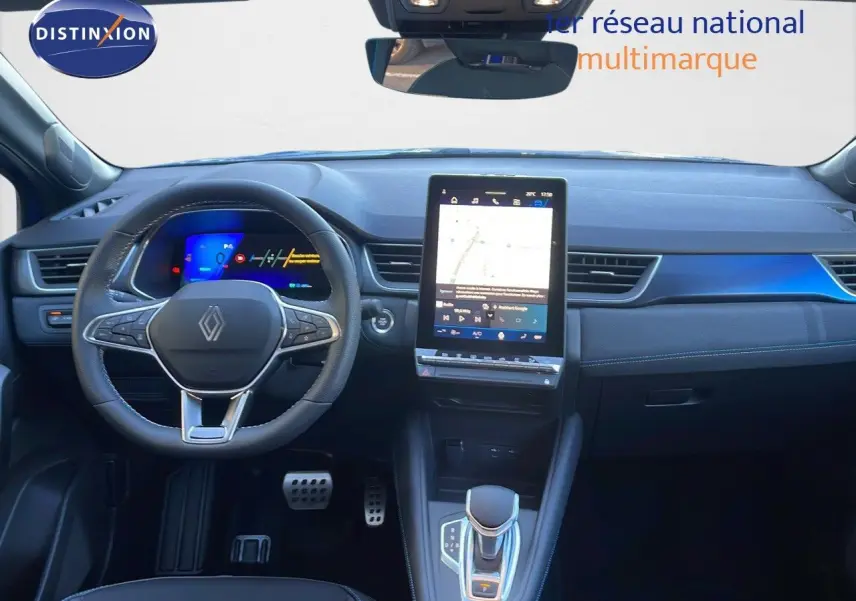 Intérieur de la Renault SYMBIOZ 2025 en bleu iron metal, vue frontale du tableau de bord avec écran tactile central et volant multifonction.