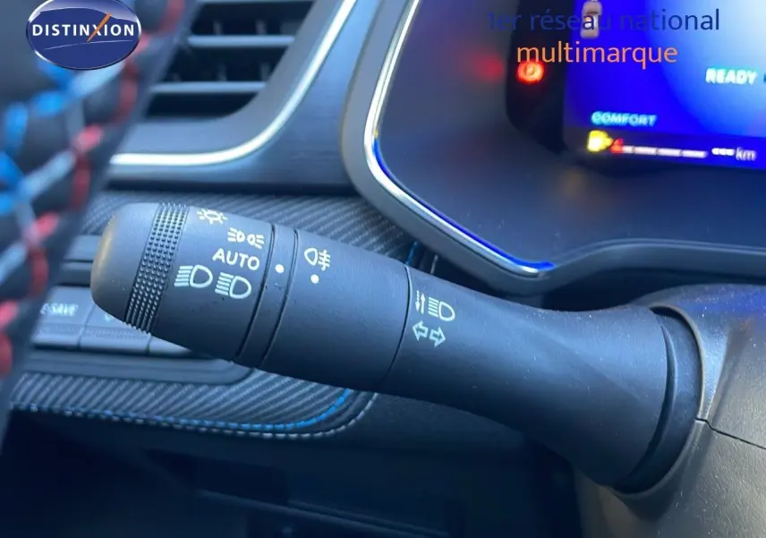 Le commodo d'éclairage du Renault Symbioz 2025 en gros plan, avec tableau de bord numérique bleu en arrière-plan.