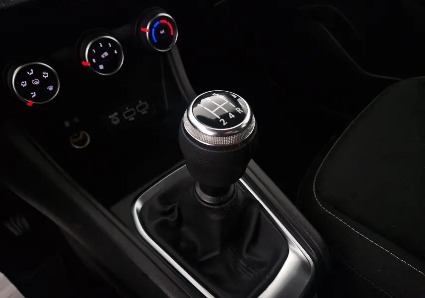 Gros plan sur le levier de vitesses manuel noir et chrome du Renault Captur 2020, avec commandes de climatisation en arrière-plan.