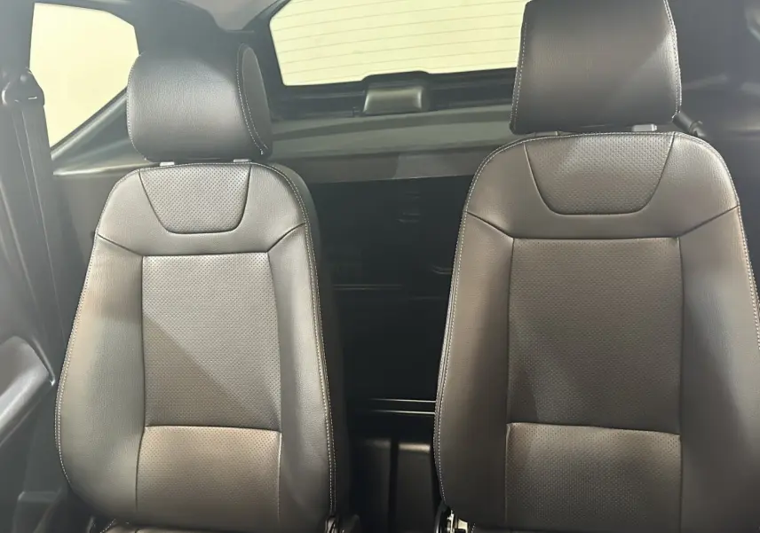 Vue intérieure rapprochée des sièges avant en cuir noir de l'AIXAM AMBITION 0.5 CITY SPORT 2026.