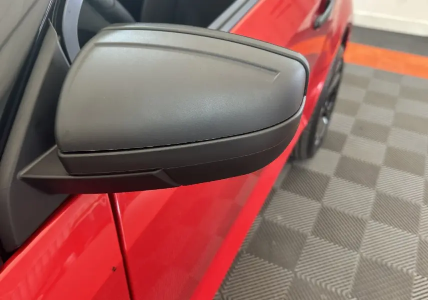 Gros plan sur le rétroviseur caméra côté conducteur d'une Aixam Ambition 0.5 City Sport rouge, vue côté gauche.