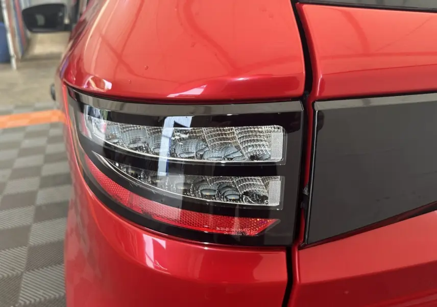 Gros plan sur le feu arrière droit rouge de l'AIXAM AMBITION 0.5 CITY SPORT 2026 avec détails noirs brillants.