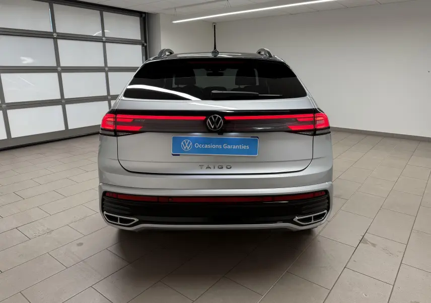 Vue arrière d'un Volkswagen Taigo 2025 argent avec toit noir, feux LED traversants et double sortie d'échappement intégrée.