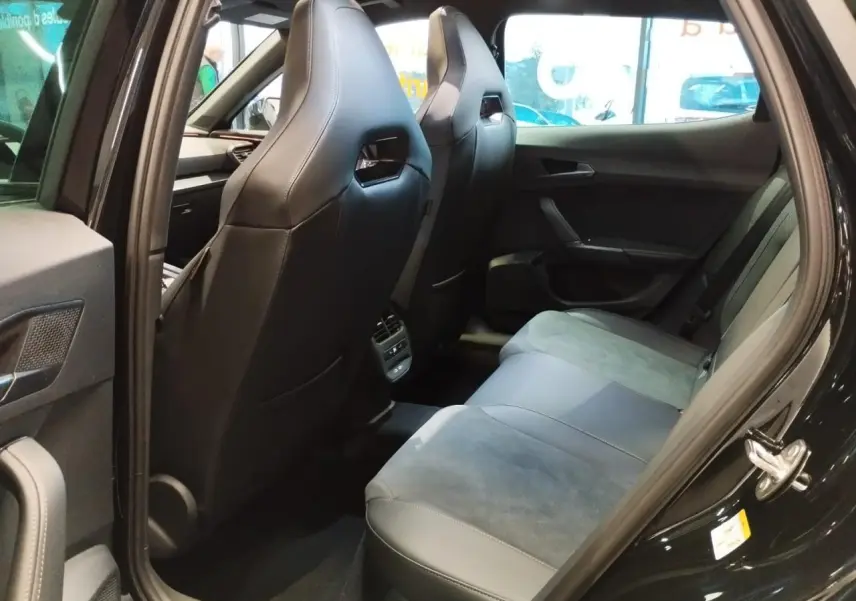 Vue intérieure arrière côté gauche du CUPRA Formentor noir métal, montrant les sièges baquets en suédine et cuir noir.