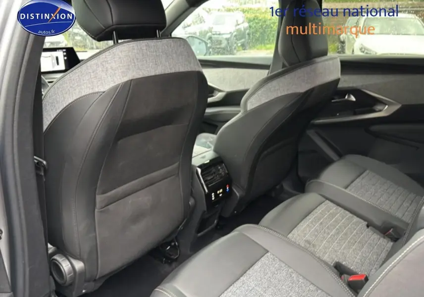 Vue intérieure arrière du Peugeot 5008 Hybrid 145 allure e-dcs6, sièges gris clair et foncé avec console centrale visible.