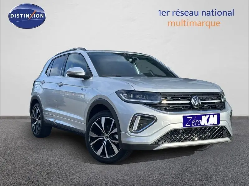 Vue 3/4 avant droit d'un Volkswagen T-Cross 1.0 TSI R-Line argenté avec jantes alliage et calandre noire chromée.