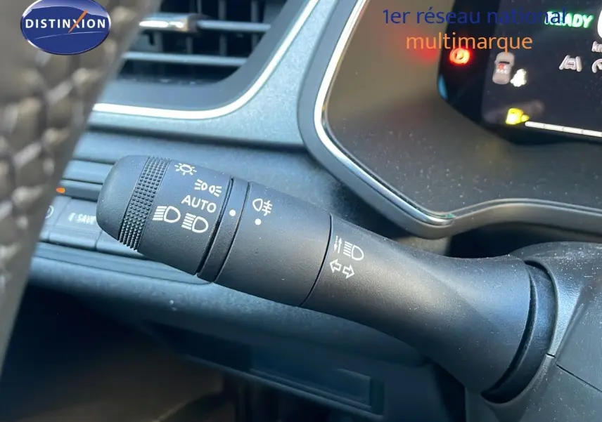 Gros plan sur la commande des feux et clignotants du Renault Captur E-Tech Hybrid 2025, tableau de bord partiel visible.