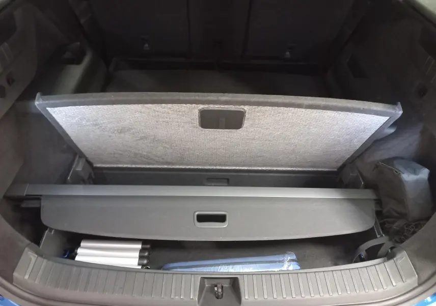 Vue plongeante sur le coffre ouvert du Skoda Kodiaq Bleu RS 2024, montrant la plage arrière et un rangement partiel.