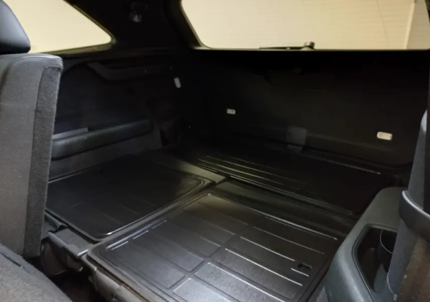 Vue intérieure du coffre du Skoda Kodiaq 2024 avec sièges arrière rabattus, montrant un espace de chargement plat et noir.