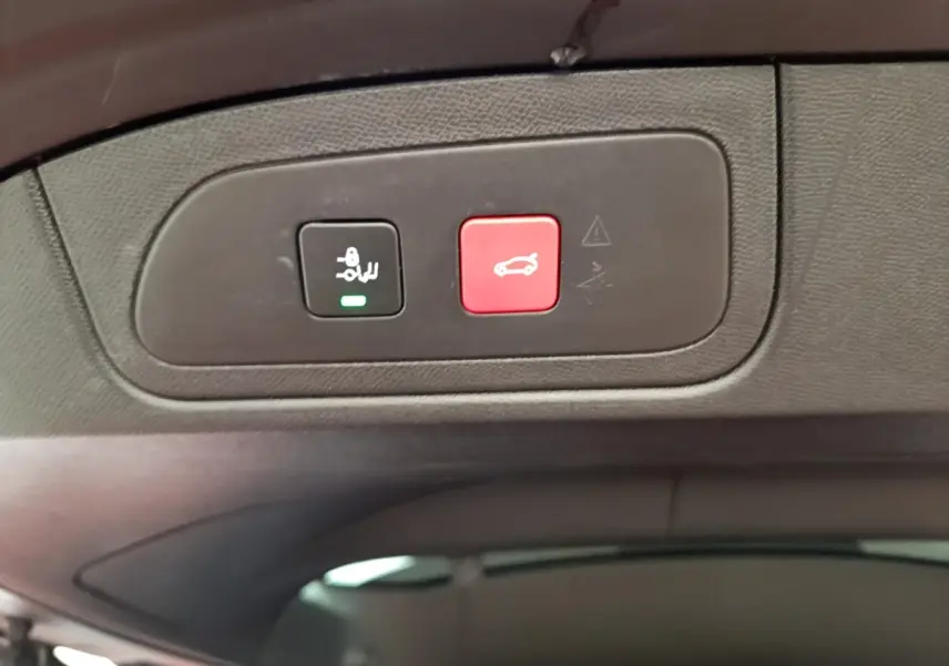 Gros plan sur les boutons de commande du coffre électrique dans l’habitacle du DS7 Crossback gris foncé.