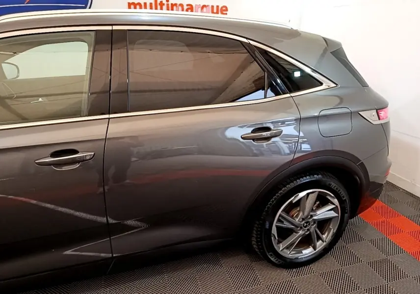 Vue côté droit arrière du DS7 Crossback E-TENSE gris foncé avec jante alliage et vitres teintées.