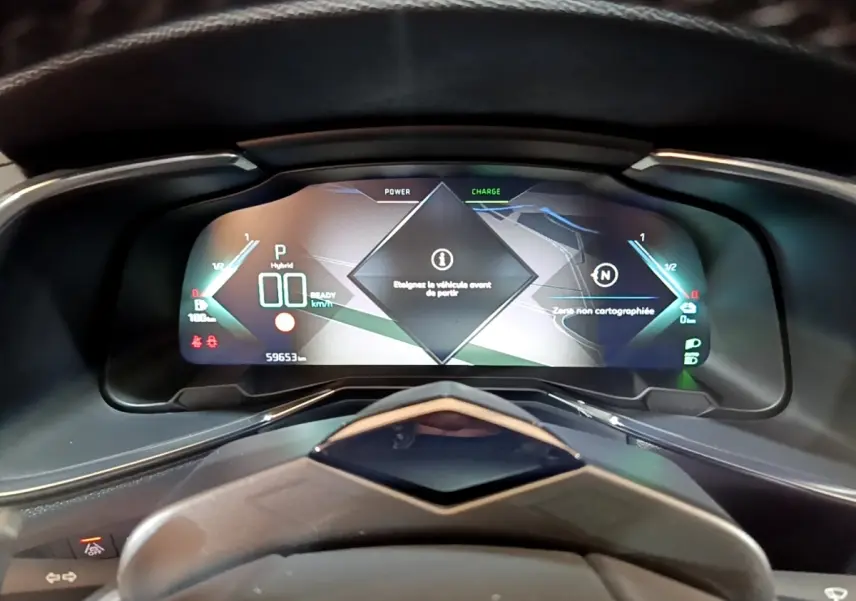 Vue rapprochée du tableau de bord numérique du DS7 Crossback E-TENSE 4x4 300 RIVOLI affichant les informations hybrides et la navigation.