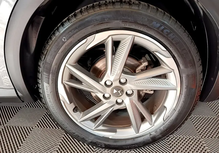 Gros plan sur la roue avant droite du DS7 Crossback E-TENSE 4x4 300 Rivoli gris foncé avec jante alliage distinctive.