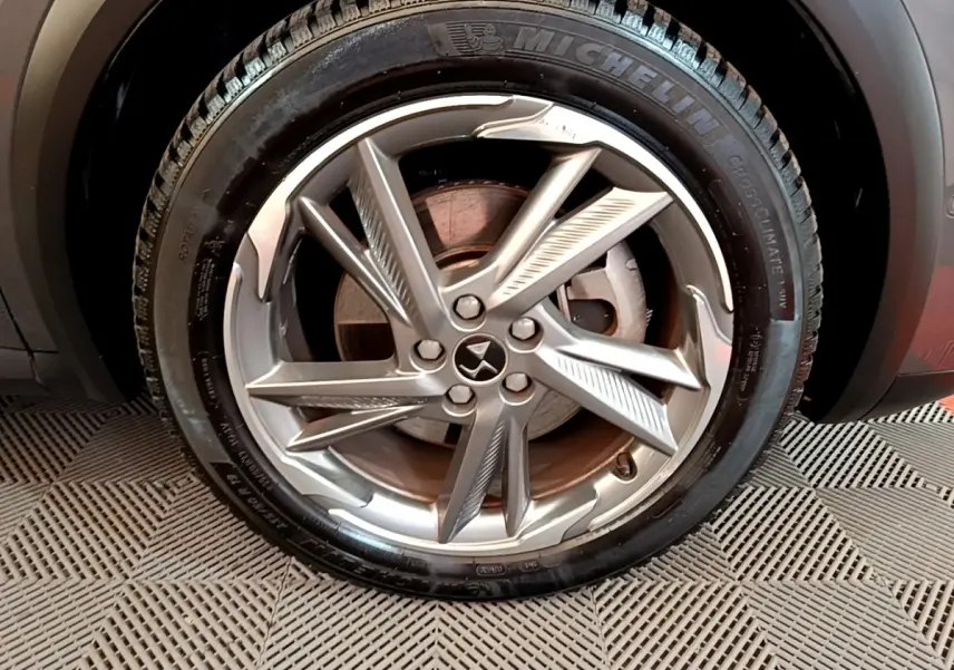 Gros plan sur la roue avant droite du DS7 Crossback gris foncé, mettant en valeur la jante alliage au design moderne.