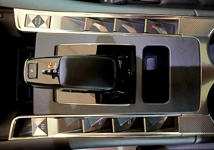 Vue plongeante sur la console centrale noire du DS7 Crossback E-TENSE 4x4 avec levier de vitesses et boutons triangulaires chromés.