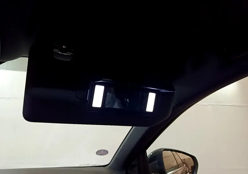Détail du miroir de courtoisie éclairé côté conducteur dans l’habitacle d’un DS7 Crossback gris foncé.