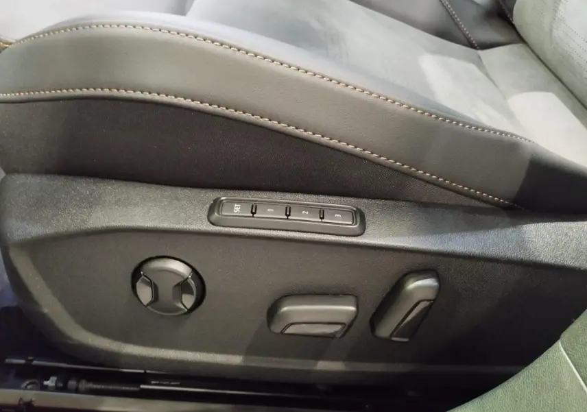 Détail du siège conducteur noir suédine avec réglages électriques et surpiqûres cuivrées dans une CUPRA Formentor noire.