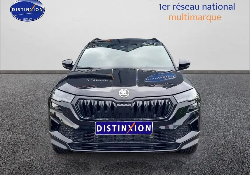 Vue frontale d'un Skoda Karoq noir 2025 avec calandre noire et logo centré sur fond neutre.