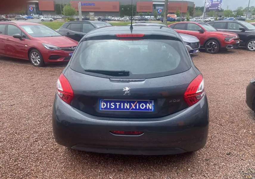 Vue arrière d'une Peugeot 208 gris shark 2013 avec plaque Distinxion sur un parking extérieur.