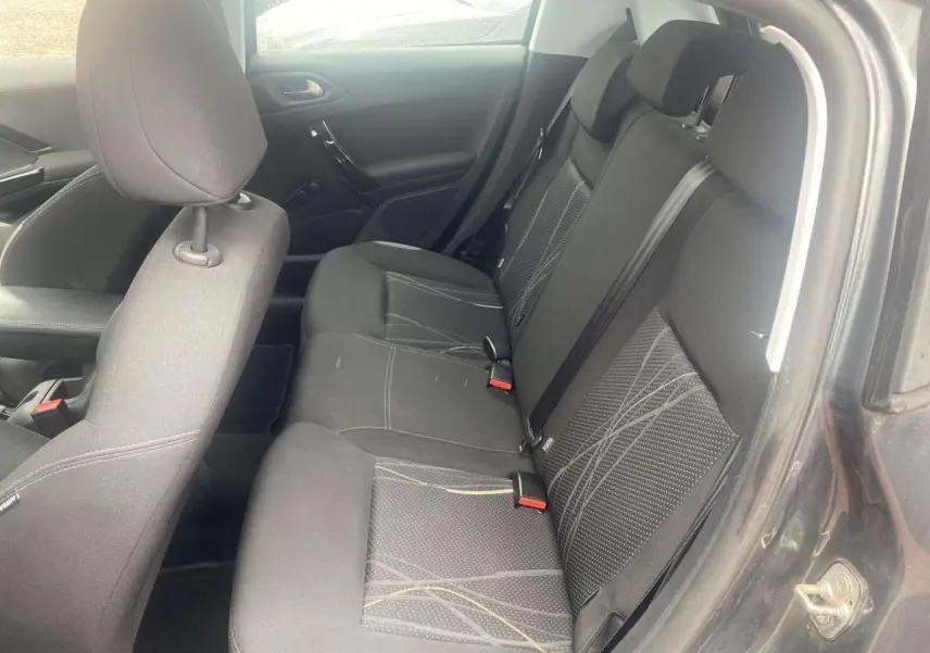 Vue intérieure côté droit des sièges arrière noirs avec motifs gris d'une Peugeot 208 gris shark de 2013.