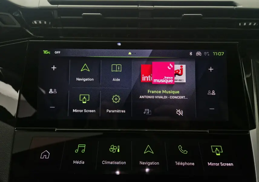 Écran tactile central du Peugeot 308 blanc Okenite 2025 affichant les menus navigation, aide, média et climatisation.
