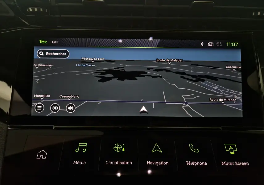 Écran tactile intérieur du Peugeot 308 blanc montrant la navigation avec carte 3D et options multimédia éclairées en vert.
